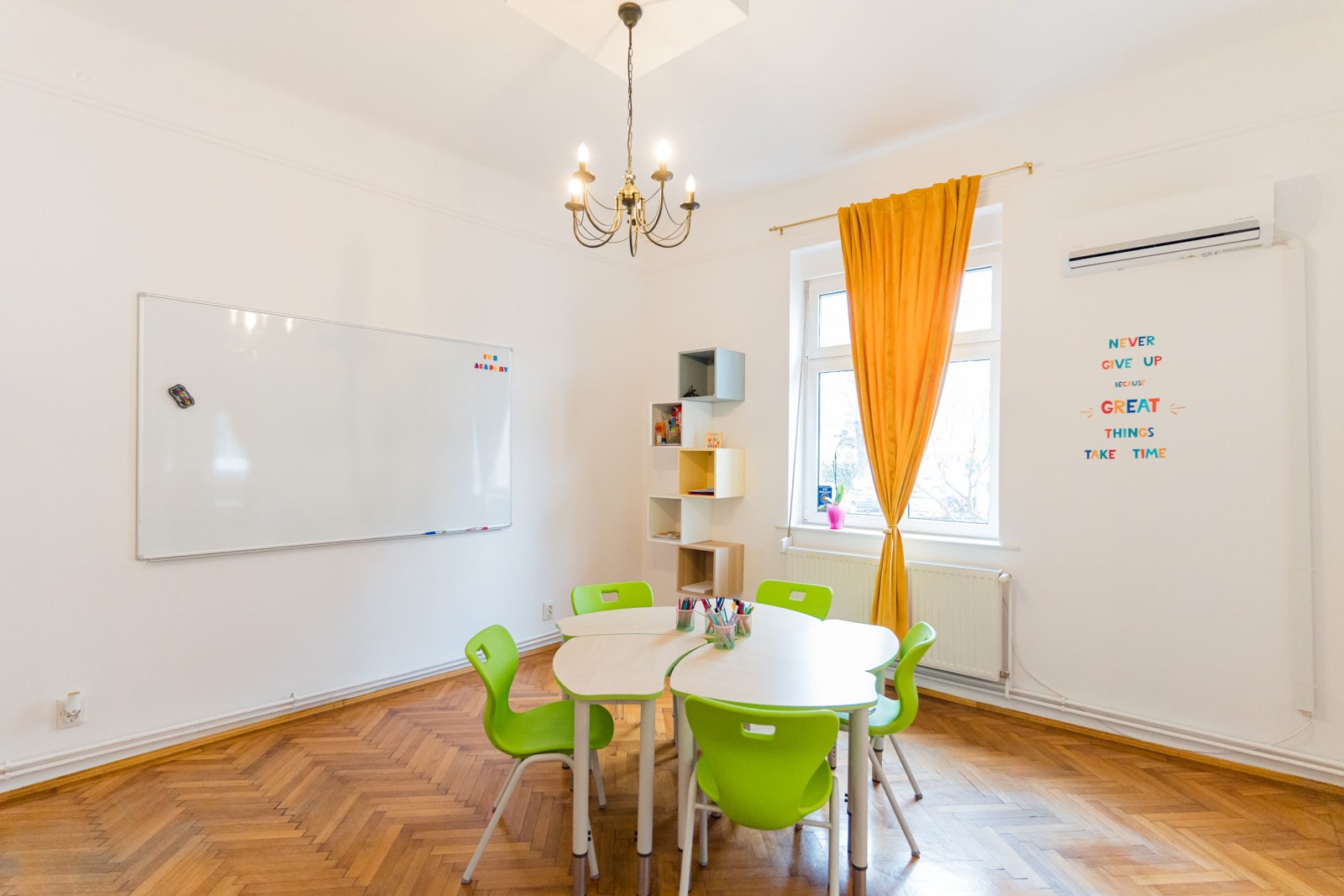 Sală luminoasă Fun Academy cu mese și scaune verzi